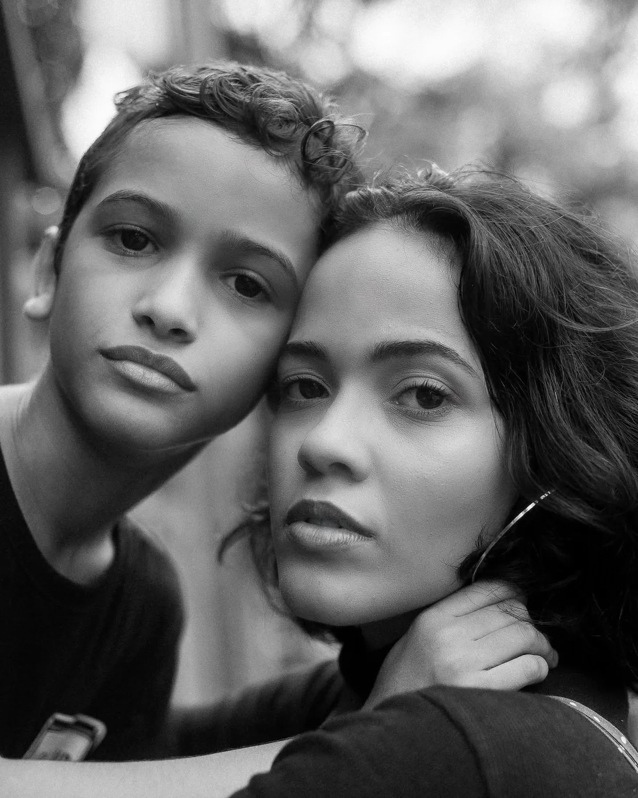 Alice Souza com o filho, rosto a rosto, retrato em preto e branco.