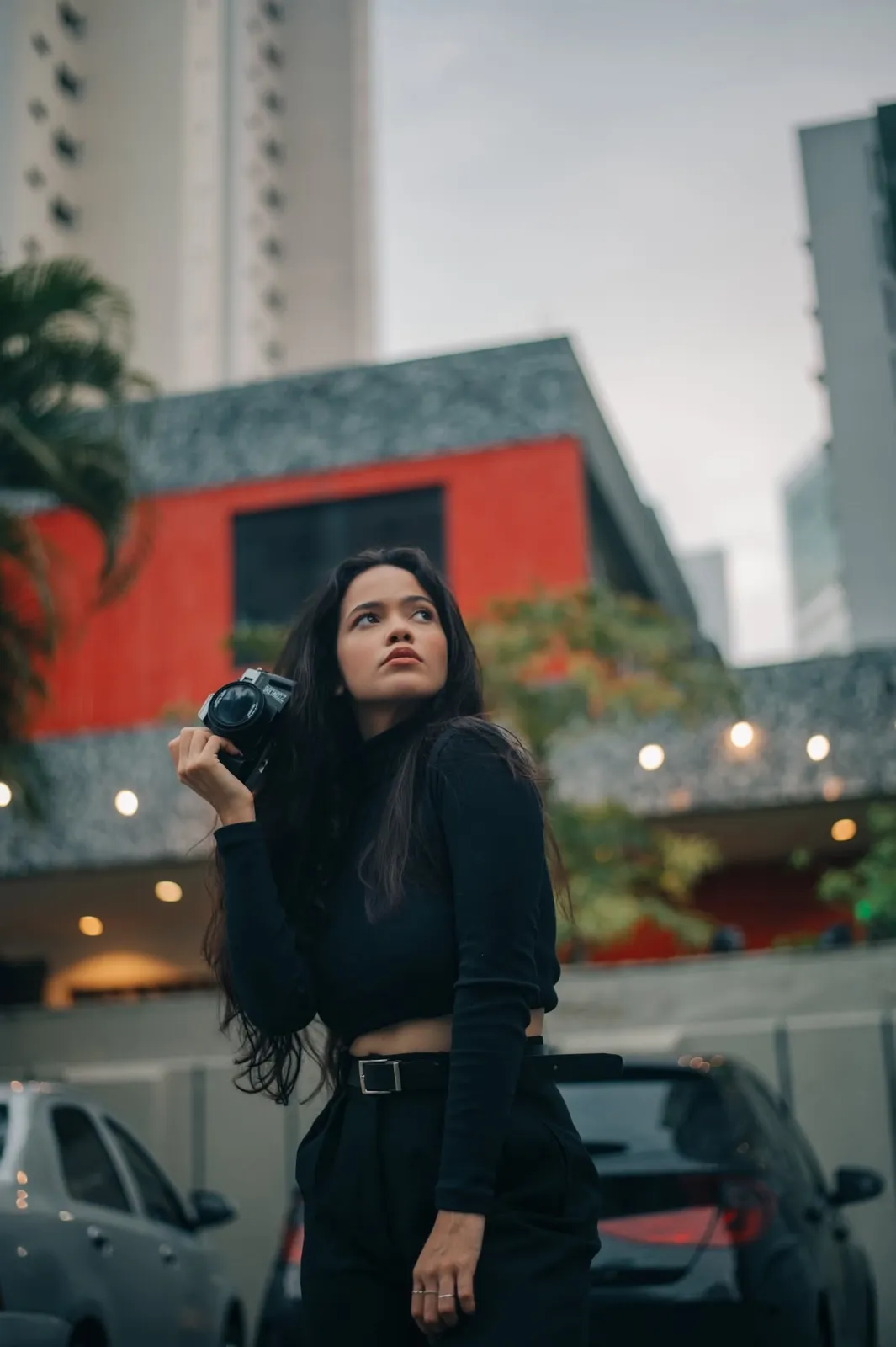 Alice fotografando na rua, câmera em punho