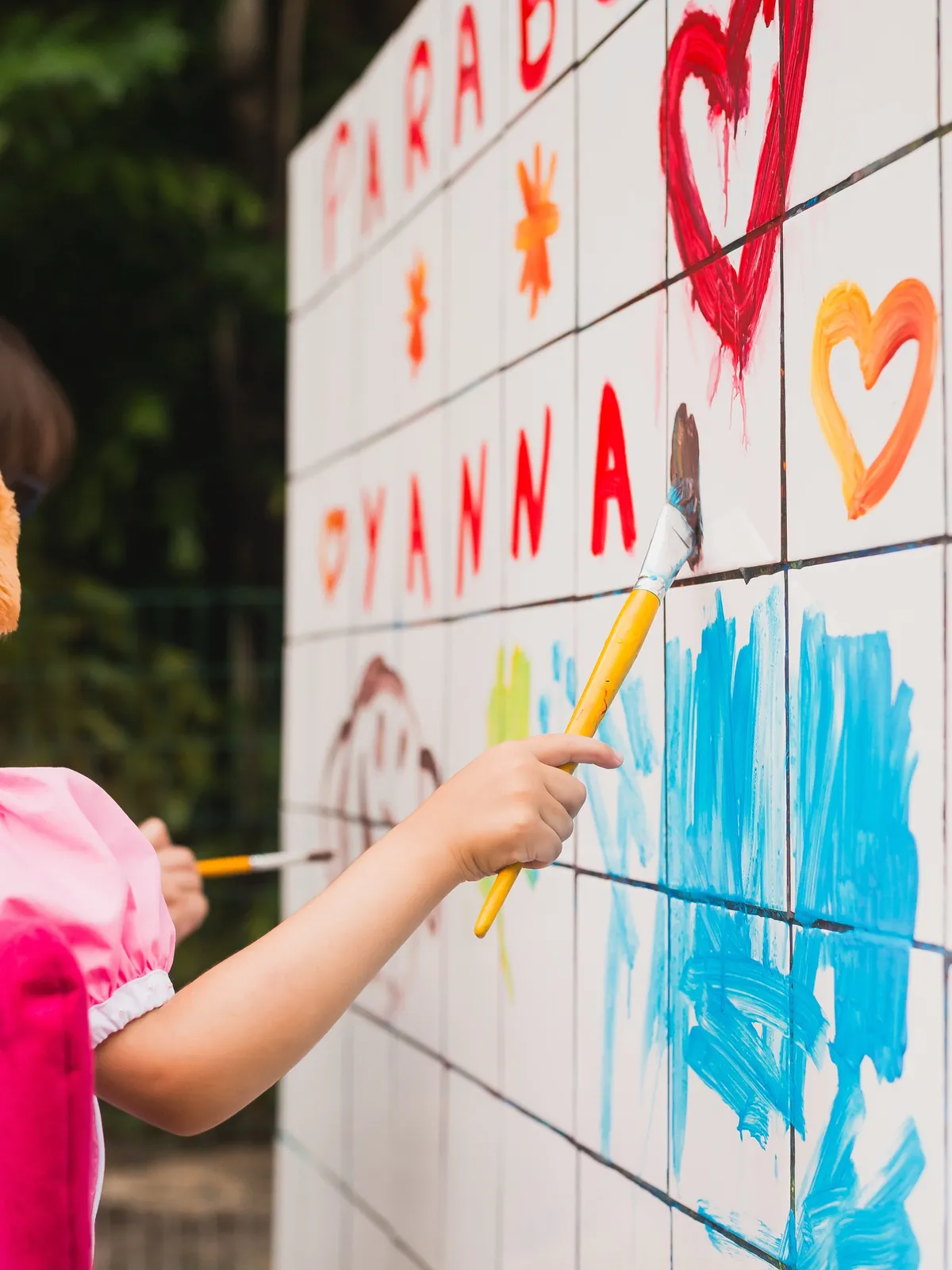 Criança pintando um painel de festa
